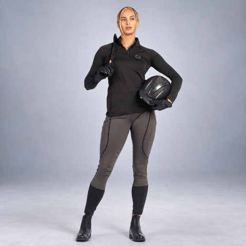 Olive knee patch riding tights with black ankle cuffs, worn by a rider
